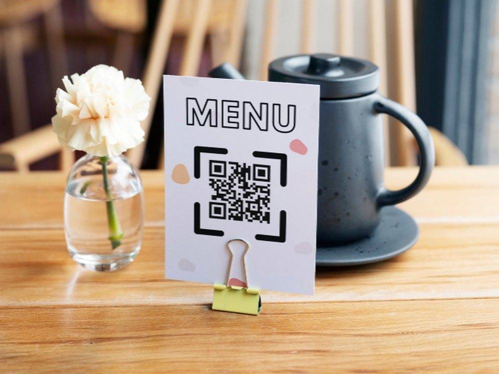 Guest scanning a ScanDine QR code standee on a restaurant table to order